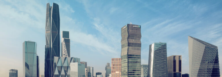 A city skyline featuring modern skyscrapers with varied and distinctive architectural designs, set against a blue sky with light clouds.